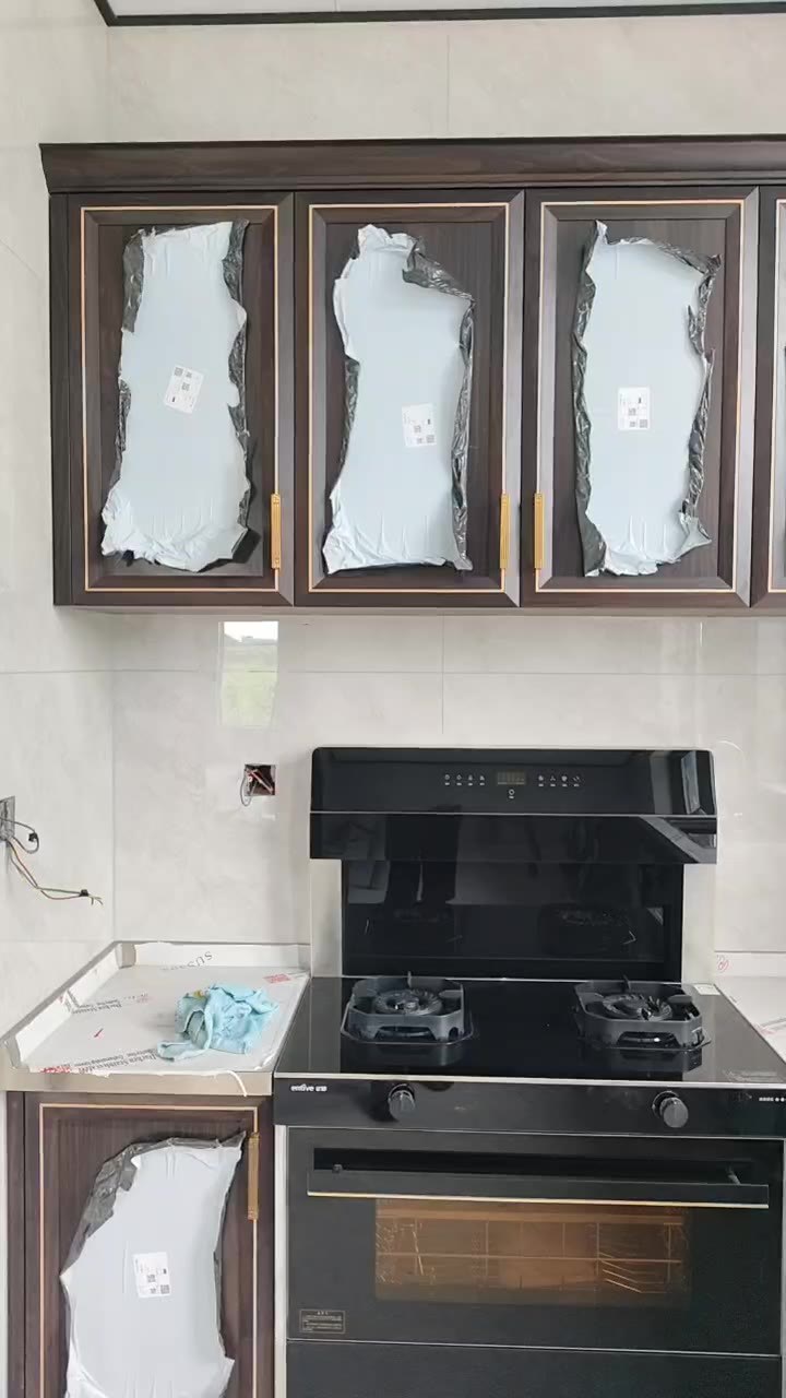 怀化欧总家集成灶段，深色门板 + 金色边框 + 带蒸烤箱的集成灶，不锈钢台面衔接